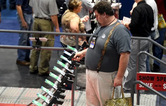 Attendees visit trade booths during the National Rifle Association's annual meeting in Nashville, Tennessee, April 11, 2015. (Photo by Harrison McClary/Reuters)