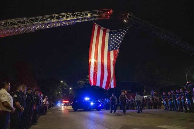 A Chicago police procession for a police officer who was shot and killed earlier during a traffic stop at 63rd and Bell drives by the Cook County Medical Examiners Office, Sunday, August 8, 2021. (Photo by Tyler LaRiviere/Chicago Sun-Times via AP Photo)