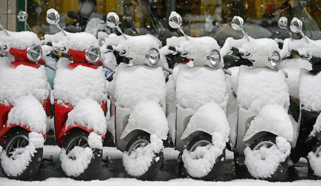 Vespas are covered with snow on a street in Zurich, Switzerland, 10 January 2019. Media reports state that many regions in Austria, Germany, Switzerland and northern Italy have been affected by heavy snowfalls in the last days. Weather forecasts warn that the snowstorms could cause roadblocks and increased avalanche danger in many parts of the affected regions. (Photo by Walter Bieri/EPA/EFE)