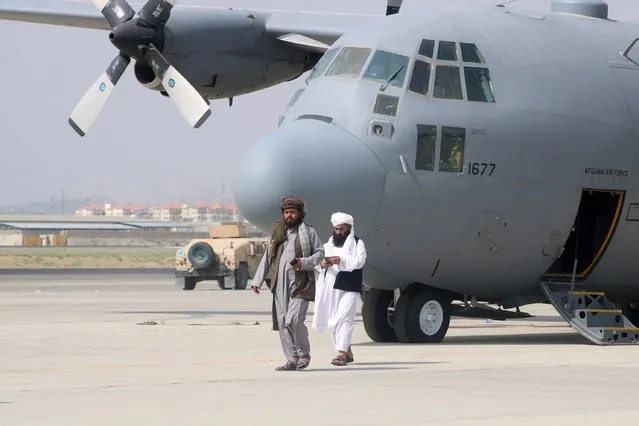 Taliban members keep guard of the Air Force aircraft at the airport in Kabul on August 31, 2021. (Photo by Reuters/Stringer)