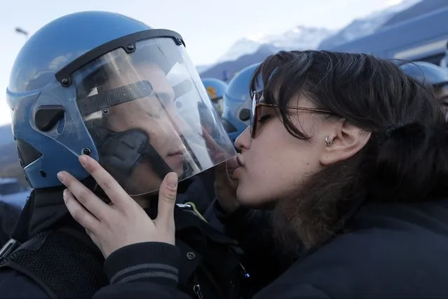 A demonstrator kisses a riot police officer during a protest in Susa, Italy, against the high-speed train (TAV in Italian) line between Lyon and Turin, on November 16, 2013. (Photo by Marco Bertorello/AFP Photo)