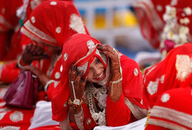 A bride reacts as she speaks with another bride during a mass marriage ceremony, in which, according to its organizers, 51 Muslim couples took their wedding vows, in Ahmedabad, India January 19, 2017. (Photo by Amit Dave/Reuters)
