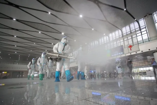 Firefighters spray disinfectant at the Yangzhou East train station in Yangzhou in China's eastern Jiangsu province on September 16, 2021. (Photo by AFP Photo/China Stringer Network)