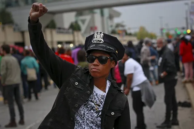 A protester wears a Baltimore police department hat taken out of a police car that was damaged during a rally to protest the death of Freddie Gray who died following an arrest in Baltimore, Maryland April 25, 2015. (Photo by Shannon Stapleton/Reuters)