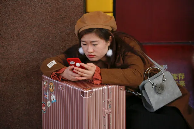 A passenger checks her phone at a waiting hall of the Beijing Railway Station in central Beijing, China January 27, 2017 as China gears up for Lunar New Year, when hundreds of millions of people head home. (Photo by Damir Sagolj/Reuters)