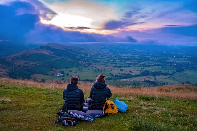 A couple make their way to the summit of Mam Tor, in the Peak District, Derbyshire, to watch the morning sunrise on Monday, August 9, 2021. (Photo by Peter Byrne/PA Images via Getty Images)