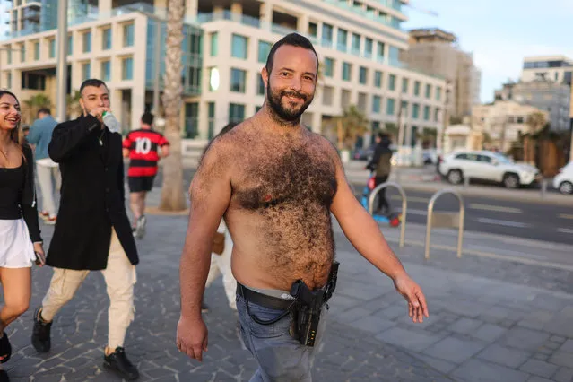 A man carries an gun as he strolls along the promeande in Tel Aviv, 20 January 2024. Since the 07 October 2023 Hamas attacks, the Israel Defense Forces (IDF) has recruited more than 300,000 reservists soldiers, while over 260,000 new applications for weapons licenses have been submitted to the Ministry of Internal Security office, the minister of national security said. The events of October 2023 had a huge impact on Israeli citizens and their sense of personal security. (Photo by Abir Sultan/EPA/EFE)