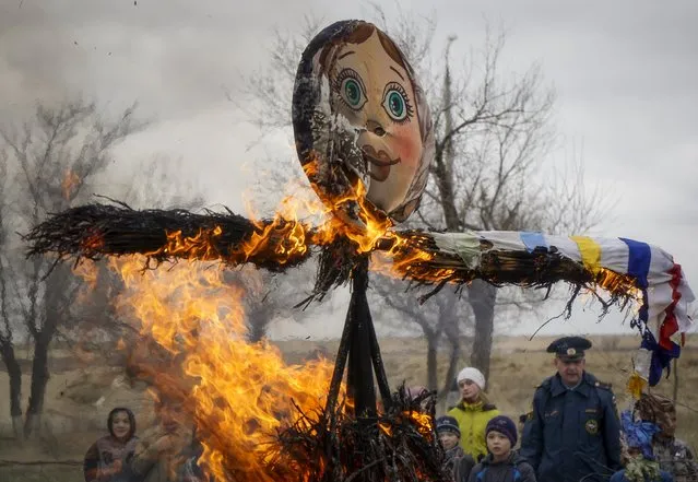 People burn an effigy of Lady Maslenitsa as they celebrate Maslenitsa, or Pancake Week, in Baikonur, Kazakhstan, March 13, 2016. (Photo by Shamil Zhumatov/Reuters)