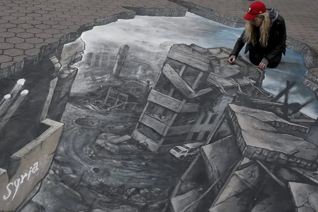 Artist Freya Clark works on a 3D art installation depicting the destruction in Syria, created with Amnesty International and Oxfam to protest against government violence in Syria, in the Manhattan borough of New York March 15, 2016. (Photo by Brendan McDermid/Reuters)