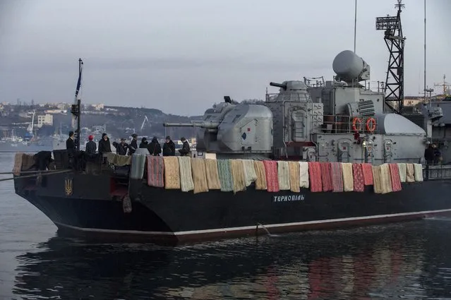 People stand on board the Ukrainian navy corvette Ternopil at harbor of  Sevastopol, Ukraine, Monday, March 3, 2014. (Photo by Andrew Lubimov/AP Photo)