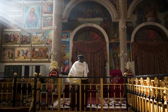 A Christian Orthodox priest stands during morning mass at the Medhane Alem Cathedral in Addis Ababa, Ethiopia, May 18, 2015. (Photo by Siegfried Modola/Reuters)