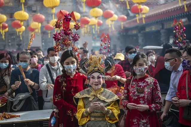 Actor Lana Wong wearing a Ox costume holds a burning joss stick prays in Wong Tai Sin Temple in Hong Kong, China on February 12, 2021. (Photo by Vernon Yuen/Rex Features/Shutterstock)