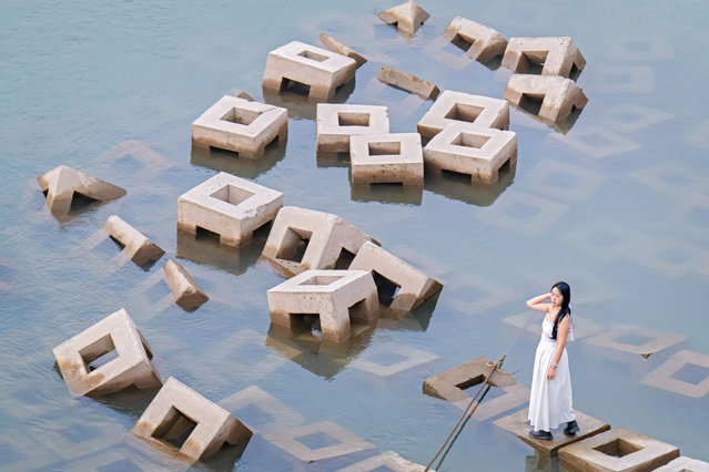 This photo taken on April 13, 2024 shows a woman standing on a breakwater in China's southwestern city of Chongqing. (Photo by AFP Photo/China Stringer Network)