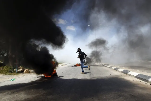 A Palestinian protester runs during clashes with Israeli troops at a protest calling for the release of Palestinian prisoners held in Israeli jails, outside Israel's Ofer military prison near the West Bank city of Ramallah April 4, 2014. Israel has called off a planned release of Palestinian prisoners meant to advance the U.S.-sponsored peace process and called for a review of how the troubled negotiations can make progress, an official briefed on the talks said on Thursday. (Photo by Mohamad Torokman/Reuters)