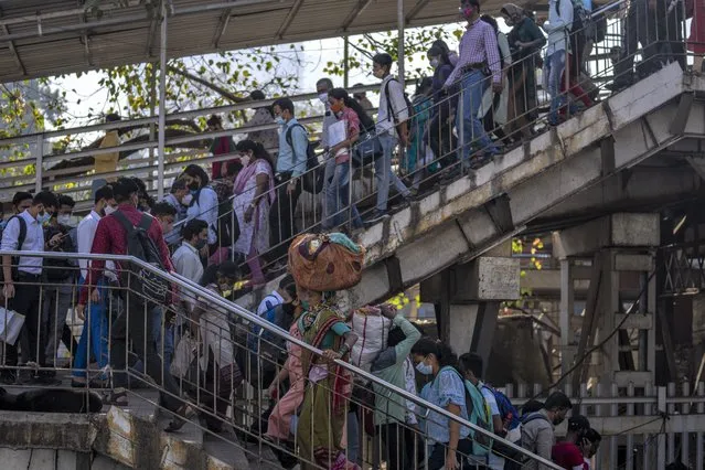 People leave a train station in Mumbai, India, Tuesday, February 1, 2022. (Photo by Rafiq Maqbool/AP Photo)