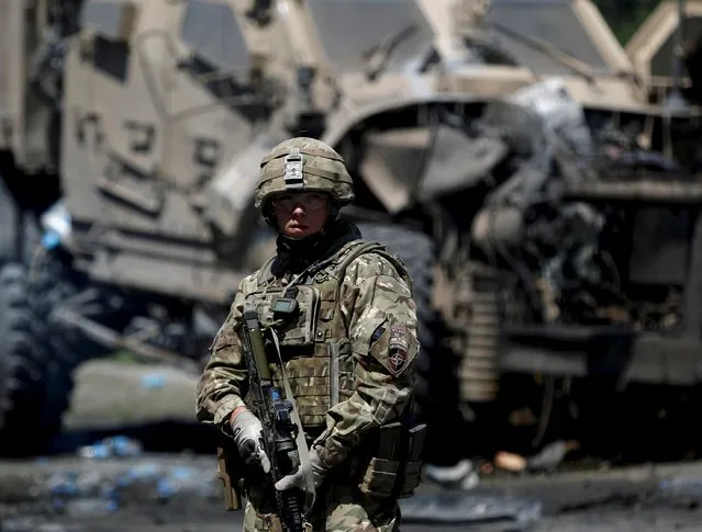A NATO soldier stands at the site of a suicide bomb attack in Kabul, Afghanistan June 30, 2015. (Photo by Ahmad Masood/Reuters)