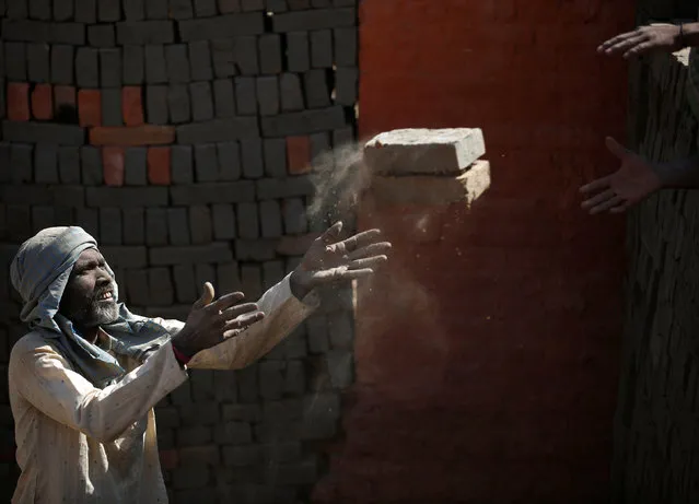 Light illuminates a worker as he passes bricks at a brick factory in Lalitpur, Nepal February 7, 2017. (Photo by Navesh Chitrakar/Reuters)