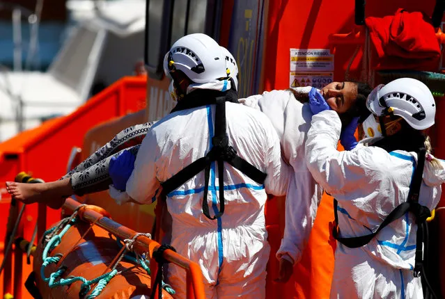 Rescuers carry a migrant to disembark from a Spanish coast guard vessel, in the port of Arguineguin, on the island of Gran Canaria, Spain on May 5, 2021. (Photo by Borja Suarez/Reuters)