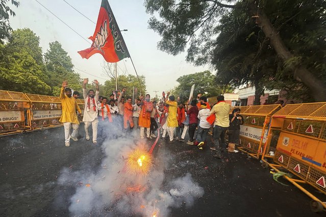 Bharatiya Janata Party (BJP) supporters light firecrackers after hearing of a candidate's victory during the counting of votes in India's national election, in New Delhi, India, Tuesday, June 4, 2024. (Photo by Manish Swarup/AP Photo)