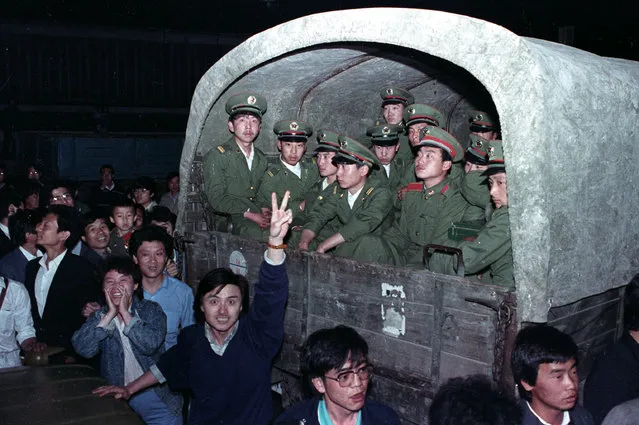 Residents of Beijing surround an army convoy of 4,000 soldiers on May 20, 1989 in a suburb of the city to prevent them from continuing to Tiananmen Square, where the pro-democracy students are. (Photo by Ed Nachtrieb/Reuters)