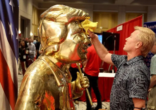 Artist Tom Zegan uses a cloth to wipe down the statue he created of former U.S. President Donald Trump at the Conservative Political Action Conference (CPAC) at The Rosen Shingle Creek on February 24, 2022 in Orlando, Florida. CPAC, which began in 1974, is an annual political conference attended by conservative activists and elected officials. (Photo by Joe Raedle/Getty Images)