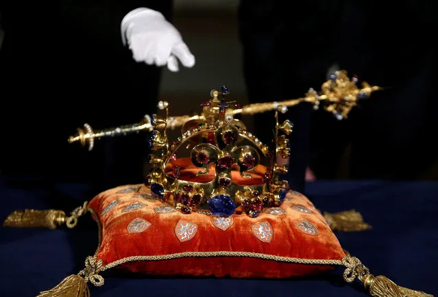 A Prague Castle curator points at the Bohemian Crown Jewels as they rest on a cushion at St. Vitus cathedral, marking the 700th anniversary of King Charles IV's birth in Prague, Czech Republic, May 12 2016. (Photo by David W. Cerny/Reuters)