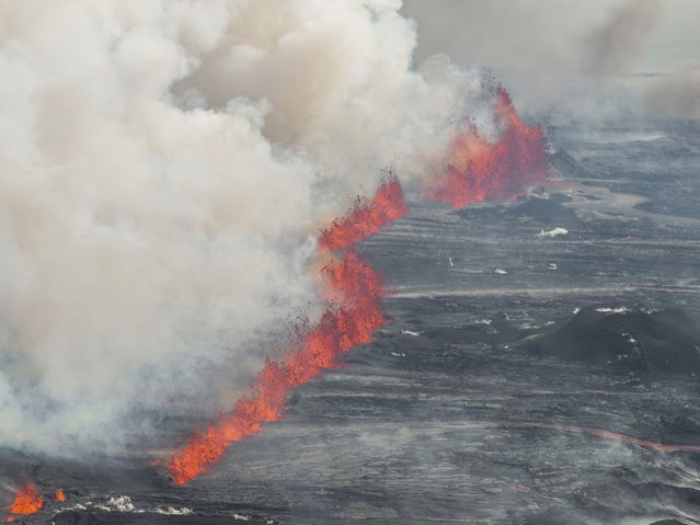 An eruptive fissure spews lava and smoke from a volcano in Grindavik, Iceland, Wednesday, May 29, 2024. A volcano in southwestern Iceland erupted Wednesday for the fifth time since December, spewing red lava that once again threatened the coastal town of Grindavik and led to the evacuation of the popular Blue Lagoon geothermal spa. (Photo by Marco di Marco/AP Photo)