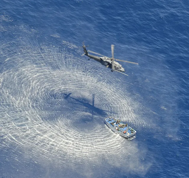 In this  May 5, 2014 photo provided by the U.S. Air Force, a U.S. Air Force HH-60G Pavehawk helicopter from the 55th Rescue Squadron hovers 600 nautical miles off the Pacific Coast of Mexico to hoist two badly burned Chinese fishermen. The two were among 17 Chinese crew members believed aboard a fishing vessel that caught fire and sank in the Pacific Ocean. Two died from burn injuries, seven were determined to be in good condition and six are believed missing, said Maj. Sarah Schwennesen of Davis-Monthan Air Force Base in Tucson, Ariz. (Photo by Staff Sgt. Adam Grant/AP Photo/U.S. Air Force)