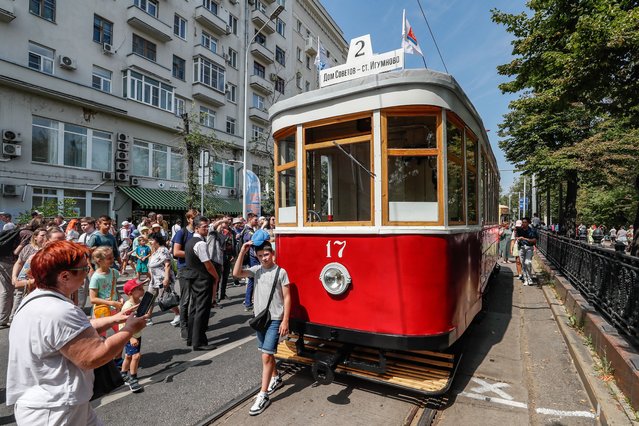 People look at the retro tram X (1927-1941) during the street exhibition “Retro Tram Parade” as part of marking the 125th anniversary of the city tramway service in Moscow, Russia on 13 July 2024. (Photo by Yuri Kochetkov/EPA/EFE)