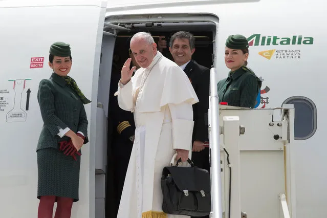 Pope Francis waves as he embarks his flight to Monte Real, Portugal, from Fiumicino's International airport, near Rome, Italy, Friday, May 12, 2017. The pope is traveling to the Sanctuary of Our Lady of Fatima where on Saturday he will canonize two poor, illiterate shepherd children whose visions of the Virgin Mary 100 years ago marked one of the most important events of the 20th-century Catholic Church. (Photo by L'Osservatore Romano/Pool Photo via AP Photo)