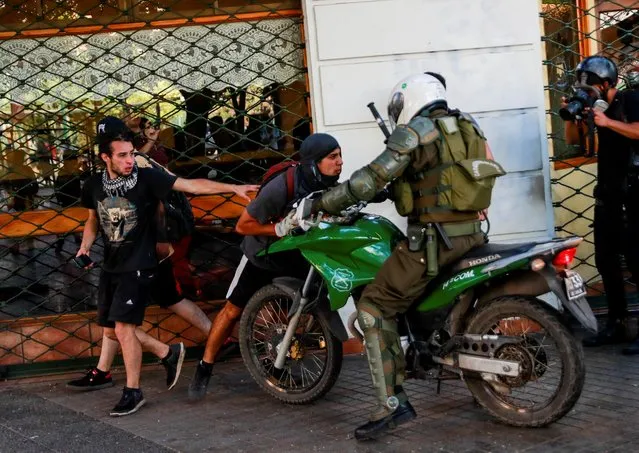 Police try to detain a man during a protest against Chile's government, at Providencia, a wealthy neighborhood, in Santiago, Chile on November 7, 2019. (Photo by Henry Romero/Reuters)