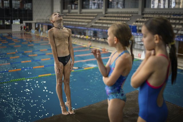 A boy dives into the water during training in Kyiv's Liko Diving School, July 3, 2024. According to Ukraine's first lady, more than 2 million children have fled the country. The departures have impacted various sports. (Photo by Alex Babenko/AP Photo)