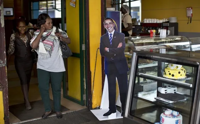 Customers walk past a cardboard cutout of President Barack Obama in the entranceway of the Cafe Deli coffee shop in downtown Nairobi, Kenya Wednesday, July 22, 2015. In his first trip to Kenya since he was a U.S. senator in 2006, Obama is scheduled to arrive in Kenya on Friday, the first stop on his two-nation African tour in which he will also visit Ethiopia. (Photo by Ben Curtis/AP Photo)