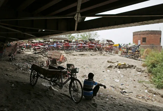 A rickshaw puller sits outside a makeshift cinema located under a bridge in the old quarters of Delhi, India May 25, 2016. (Photo by Cathal McNaughton/Reuters)