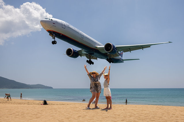 Russian tourists pose for photos with inbound planes on Mai Khao Beach on March 24, 2024 in Phuket, Thailand. The upcoming season of “The White Lotus” is anticipated to have a massive impact on tourism in Thailand, with travel forecasters predicting a surge in visitors to destinations like Koh Samui, Phuket, and Bangkok. The allure of experiencing the real-life locations featured in the series is expected to fuel a travel trend, drawing attention to Thailand as a top-tier bucket list destination for global travellers. (Photo by Lauren DeCicca/Getty Images)