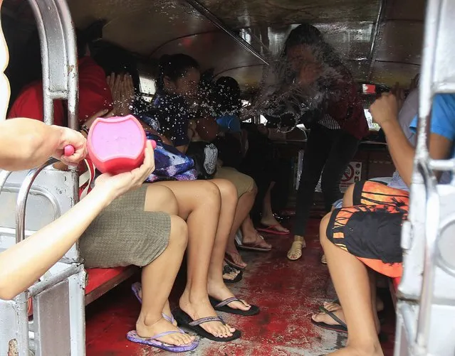 A resident douses passengers riding in a public vehicle with water, during St. John the Baptist Feast Day celebrations in San Juan city, metro Manila June 24, 2014. Residents participate in an annual city-wide waterfest in honour of their patron Saint John the Baptist. (Photo by Romeo Ranoco/Reuters)
