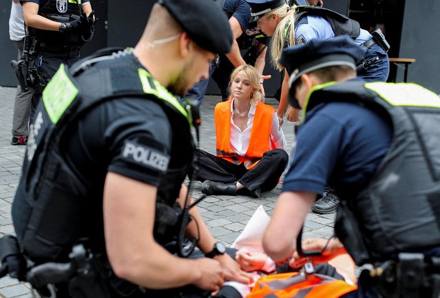 Climate Change activists of “Letzte Generation” (last generation) are detained by German police as they protest against the German Industry Day, hosted by the BDI (Federation of German Industries) industry association, in Berlin, Germany on June 19, 2023. (Photo by Nadja Wohlleben/Reuters)