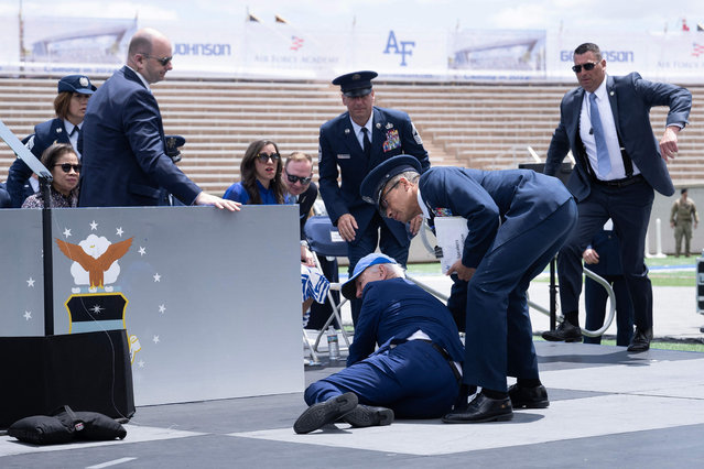 US President Joe Biden is helped up after falling during the graduation ceremony at the United States Air Force Academy, just north of Colorado Springs in El Paso County, Colorado, on June 1, 2023. (Photo by Brendan Smialowski/AFP Photo)