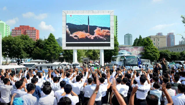 People watch a huge screen showing the test launch of intercontinental ballistic missile Hwasong-14 in this undated photo released by North Korea's Korean Central News Agency (KCNA), July 5, 2017. (Photo by Reuters/KCNA)