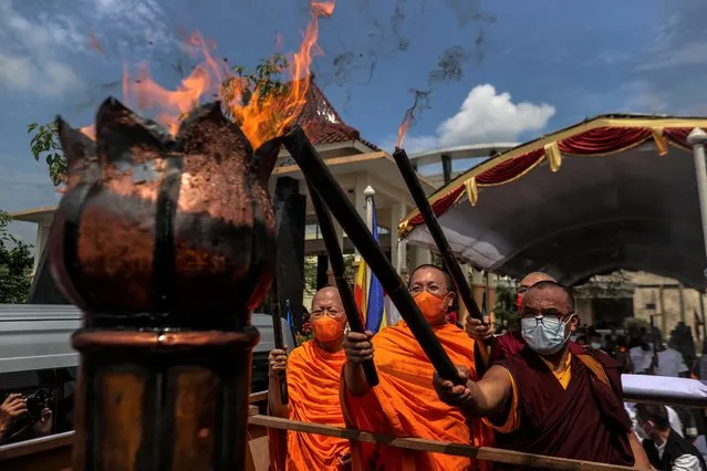Buddhist monks put fire torches during Api Abadi Mrapen procession as a part of celebrations for Vesak Day on May 14, 2022 in Grobogan Regency, Central Java, Indonesia. Buddhists in Indonesia celebrated Vesak Day on Monday to honour the birth, enlightenment, and death of Buddha more than 2,000 years ago. (Photo by Garry Lotulung/NurPhoto via Getty Images)