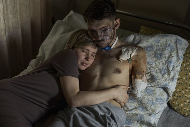 Alina, left, hugs her husband Andriy in a hospital in Kyiv, Ukraine, Monday, July 10, 2023. Andriy is a Ukrainian army 47th brigade air reconnaissance officer, code name Apostle, who was heavily wounded in a battle with Russian troops in the Zaporizhzhia region. (Photo by Libkos/AP Photo)