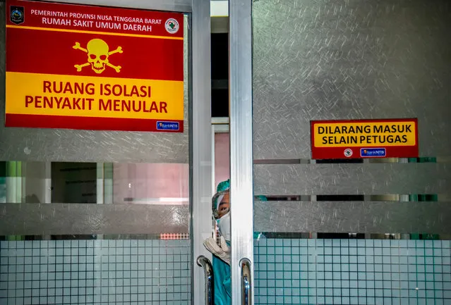 An Indonesian medical worker looks out of an isolation area, to be occupied by patients showing symptoms of a deadly virus outbreak which began in the Chinese city of Wuhan, at a public hospital in Mataram, West Nusa Tenggara on January 28, 2020. The virus, which can cause a pneumonia-like acute respiratory infection, has in a matter of weeks killed more 106 people and infected more than 4,000 in China, while cases have been identified in more than a dozen other countries. (Photo by Moh El Sasaky/AFP Photo)