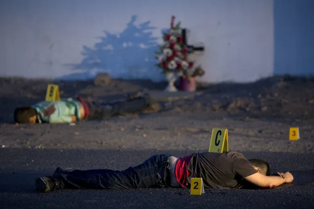 In this early Thursday, June 29, 2017 photo, numbers placed by investigators sit on top of two of bodies found lying on a road in the town of Navolato, Sinaloa state, Mexico. 59 AK type and AR-15 casings were found in the area. Early Saturday, July 1st, Mexican authorities said that at least 19 people died in clashes between armed men and security forces earlier in the town of Villa Union, about 15 miles (24 kilometers) southeast of the beach resort of Mazatlan. Violence has spiked dramatically in the gang-plagued northwestern state of Sinaloa, following the capture and extradition of convicted drug lord Joaquin “El Chapo” Guzman. (Photo by Enric Marti/AP Photo)