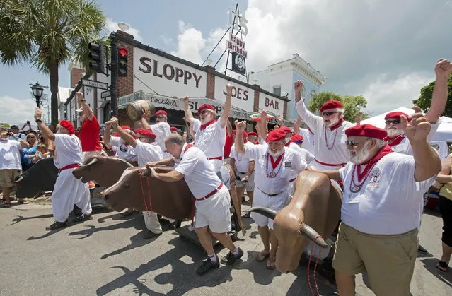 Participants in the annual Ernest Hemingway look-alike contest negotiate a turn during the “Running of the Bulls” in Key West, Florida in this July 19, 2014 handout photo provided by the Florida Keys News Bureau. The event, a parody of its namesake in Pamplona, Spain, is one of many during Key West's Hemingway Days festival that continues through July 20, 2014. Hemingway lived and wrote in Key West throughout most of the 1930s. (Photo by Andy Newman/Reuters/Florida Keys News Bureau)