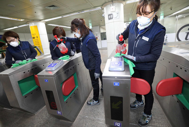 Seoul Metro employees spray disinfectant as part of efforts to prevent the spread of a new virus which originated in the Chinese city of Wuhan, at a subway station in Seoul on January 28, 2020. South Korea will send chartered planes to the Chinese city of Wuhan this week to return hundreds of its citizens to Korea, the foreign ministry said, amid concerns about the spread of the SARS-like virus. (Photo by Yonhap/AFP Photo)