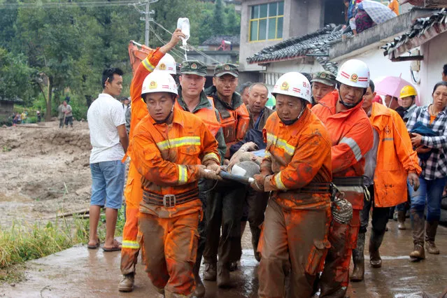 Rescue workers carry an injured villager at the site of a landslide that occurred in Gengdi village, Puge county, Sichuan province, China August 8, 2017. (Photo by Reuters/China Stringer Network)