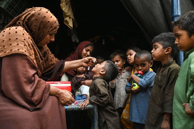 Health workers administer polio drops to children during a door-to-door vaccination campaign in Lahore on October 28, 2024. (Photo by Arif Ali/AFP Photo)