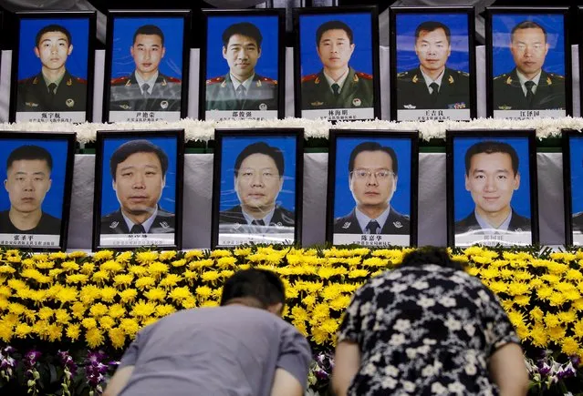 People pay tribute to firefighters who died, marking the seventh day since the Tianjin explosions, in a mourning ceremony at Binhai new district, Tianjin, China, August 18, 2015. The death toll has risen to 114, with more than 700 people injured and another 70, mostly fire fighters, still missing. The blasts devastated a large industrial site and nearby residences and sent shockwaves across several kilometres. (Photo by Reuters/China Daily)
