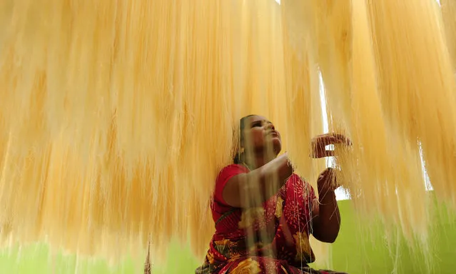 An Indian woman sorts strands of drying seviiyan – thin vermicelli – which is used for the preparation of “sheerkhorma”, a traditional sweet dish prepared by muslims during the holy month of Ramadan, at a food factory in Chennai on June 28, 2016. Muslims around the world celebrate the month of Ramadan by abstaining from eating, drinking, and smoking as well as sexual activities from dawn to dusk. (Photo by Arun Sankar/AFP Photo)