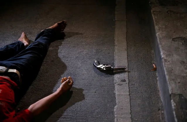 A rusty revolver is seen near the body of a man, who police said was killed by police operatives, and two sachets of “Shabu” or methampethamine chloride were found on his pockets in Manila, Philippines August 17, 2017. (Photo by Erik De Castro/Reuters)